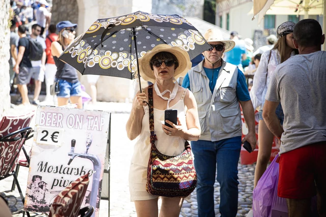 Turisti se štite kišobranima, šeširima...