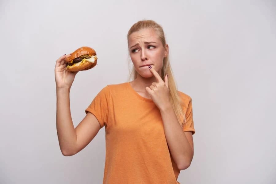 Plavuša sa burgerom u ruci